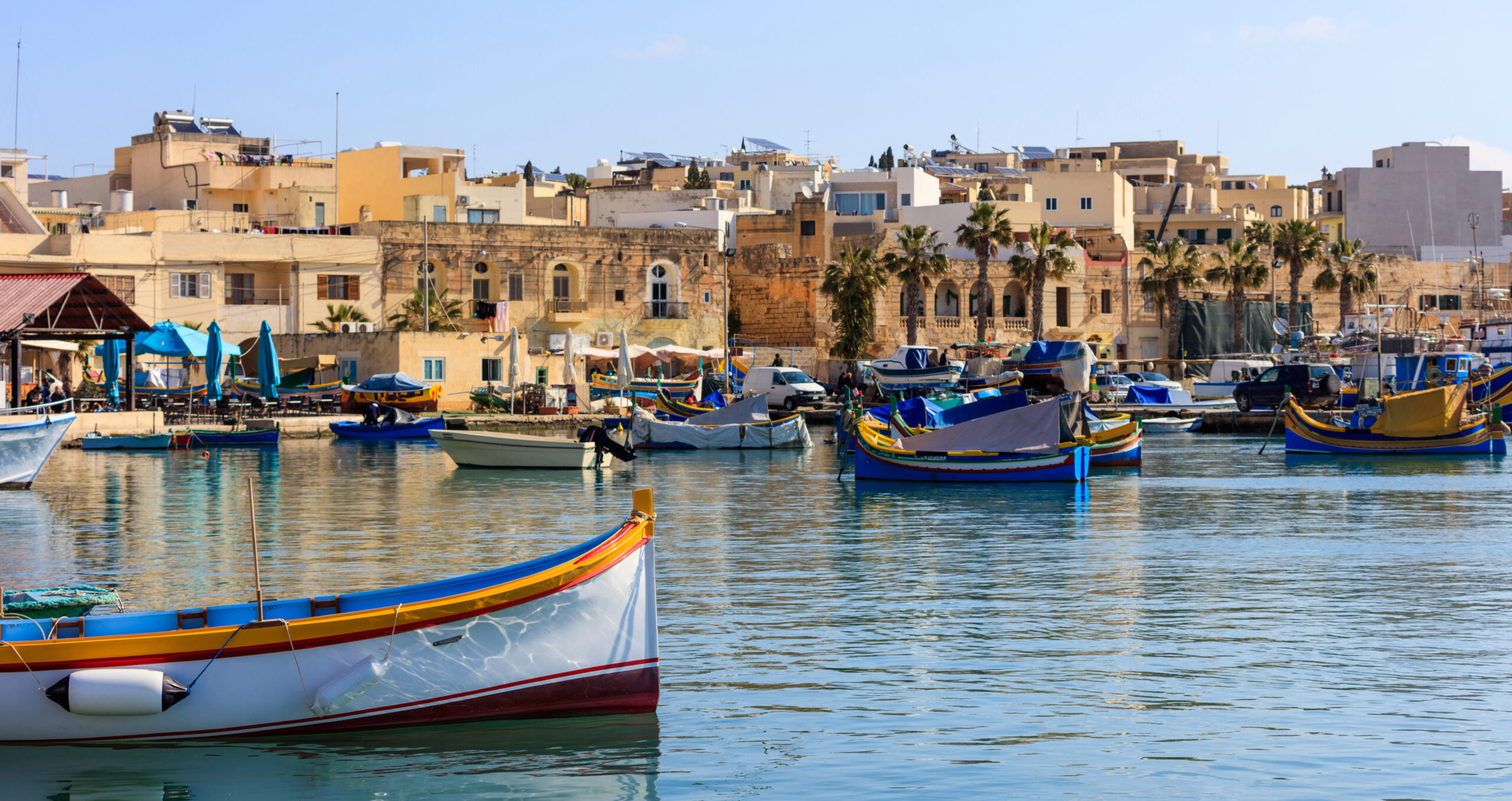 Marsaxlokk fishermen village in Malta. Traditional colorful boats at the port of Marsaxlokk
